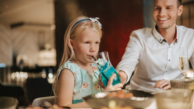 Lapsi pöydässä juomassa lasten cocktailia